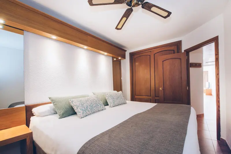Une chambre lumineuse avec un grand lit recouvert d'une courtepointe.