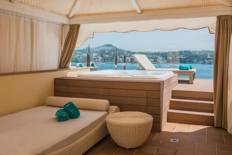 Espace de détente extérieur avec jacuzzi et vue sur la mer.