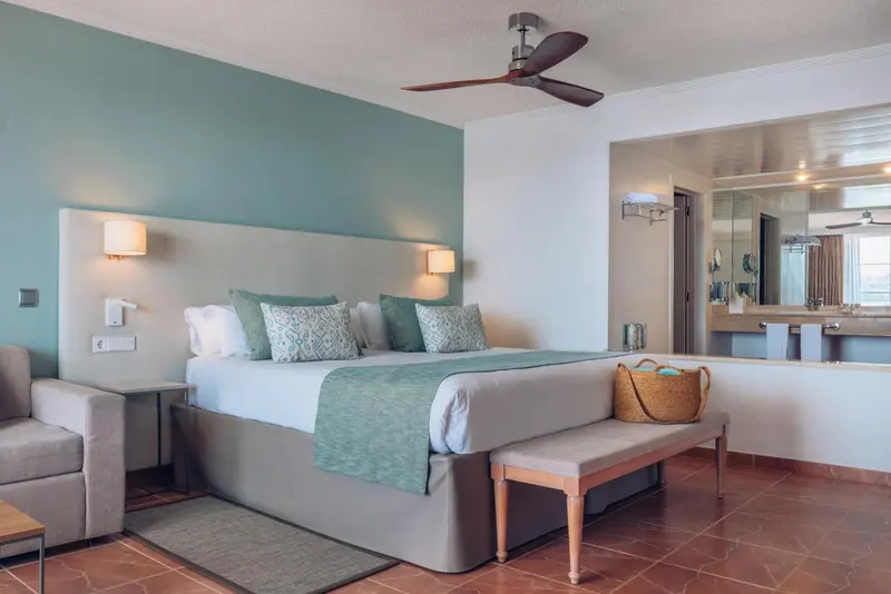 Une chambre lumineuse avec un grand lit et un miroir.