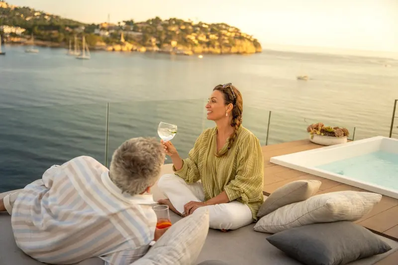 Un couple profite d'un moment de détente sur une terrasse avec vue sur la mer.