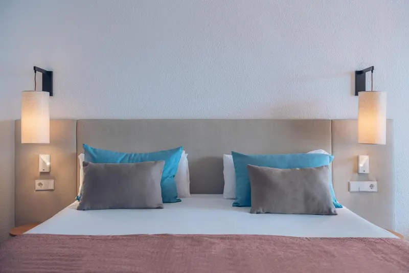 Un lit double avec des oreillers et des coussins dans une chambre.