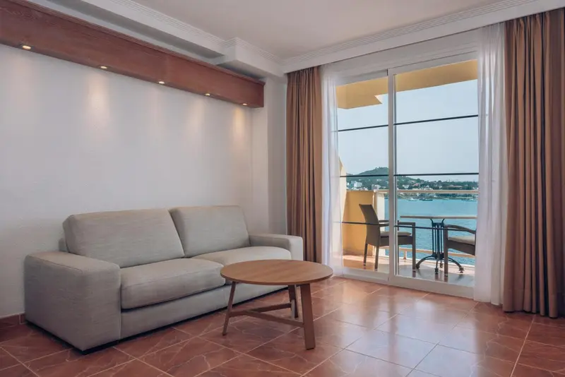 Un salon lumineux s'ouvre sur une terrasse avec vue sur la mer.
