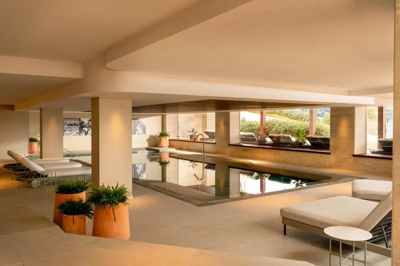 Espace de détente intérieur avec piscine et mobilier de relaxation.