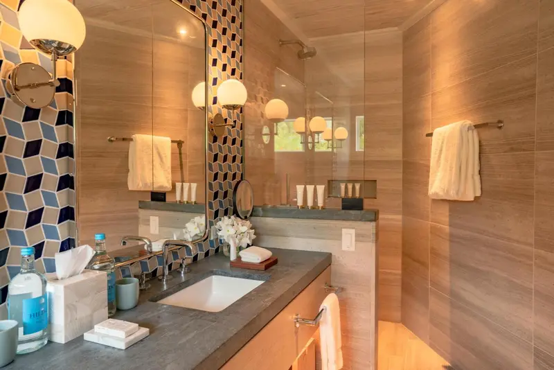 Une salle de bain moderne avec une douche à l'italienne et un grand miroir.