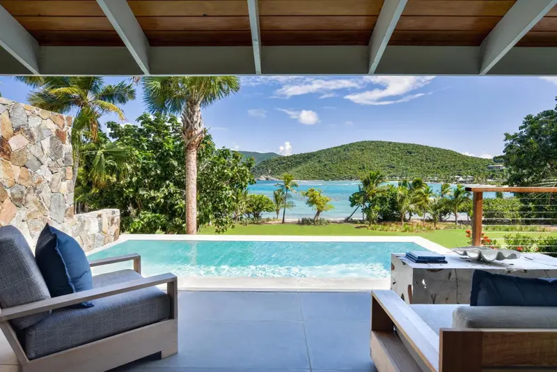 Espace de détente extérieur avec piscine et vue sur la mer.