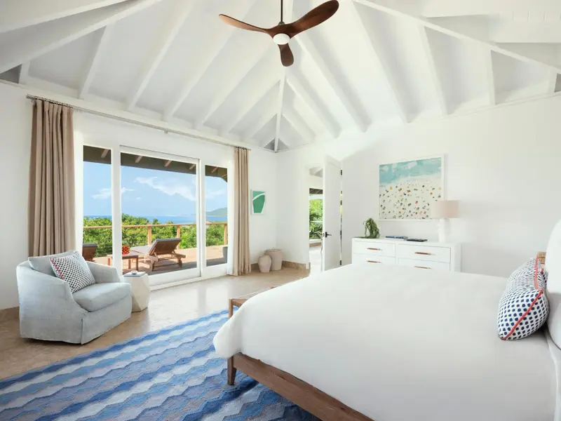 Une chambre lumineuse s'ouvre sur une terrasse avec vue sur la mer.