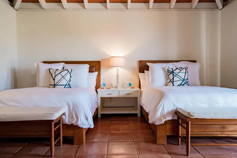 Une chambre lumineuse avec deux lits simples et une décoration sobre.