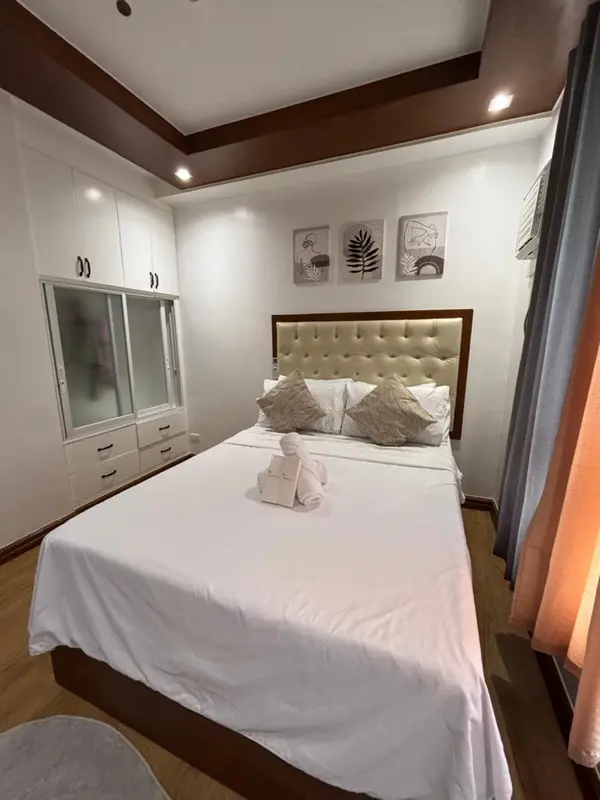 Une chambre lumineuse avec un grand lit recouvert de draps blancs et de coussins.