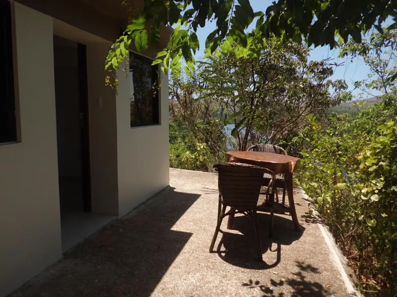 Une terrasse avec une table et des chaises en osier offre un espace de détente extérieur.