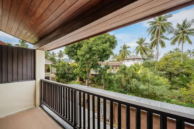 Terrasse ombragée donnant sur une végétation tropicale luxuriante.