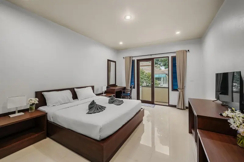 Une chambre lumineuse avec un grand lit et un accès à une terrasse.