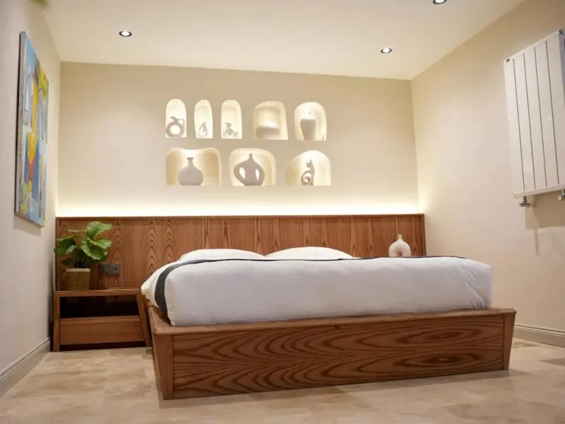 Une chambre lumineuse avec un grand lit et une décoration murale originale.
