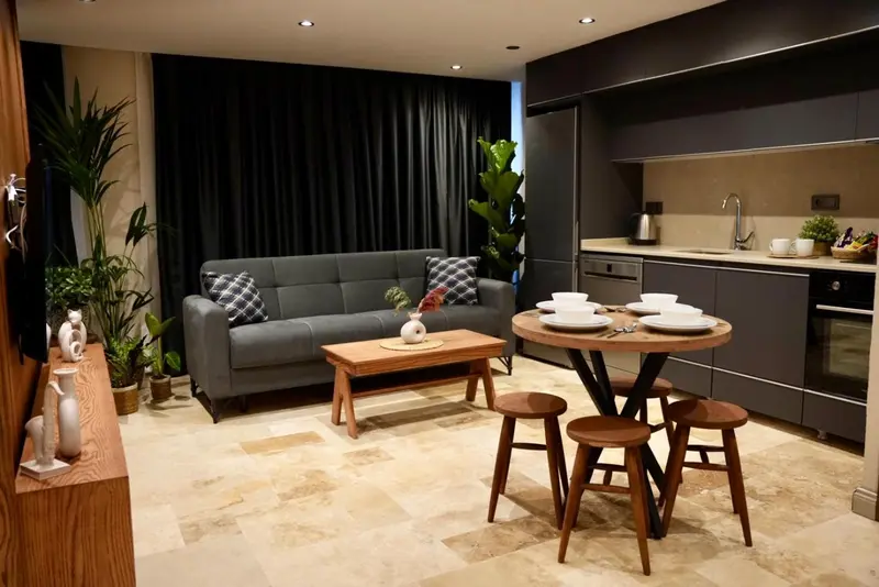 Espace de vie intérieur avec canapé, table basse et cuisine équipée.