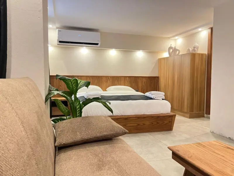 Une chambre lumineuse avec un grand lit et un coin salon.