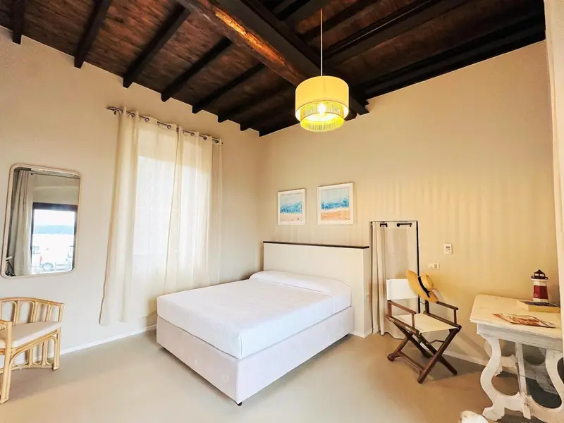 Une chambre lumineuse avec un lit double et une décoration sobre.