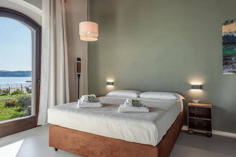 Une chambre lumineuse avec un grand lit et une vue sur la mer.
