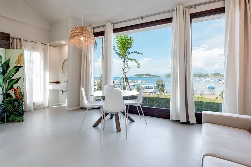 Une salle à manger lumineuse donne sur une vue maritime.