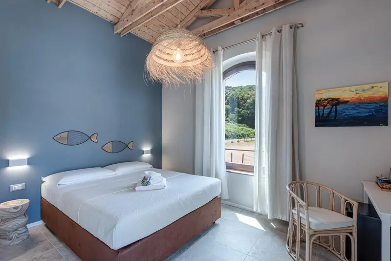 Une chambre lumineuse avec un lit fait et une vue sur la mer.