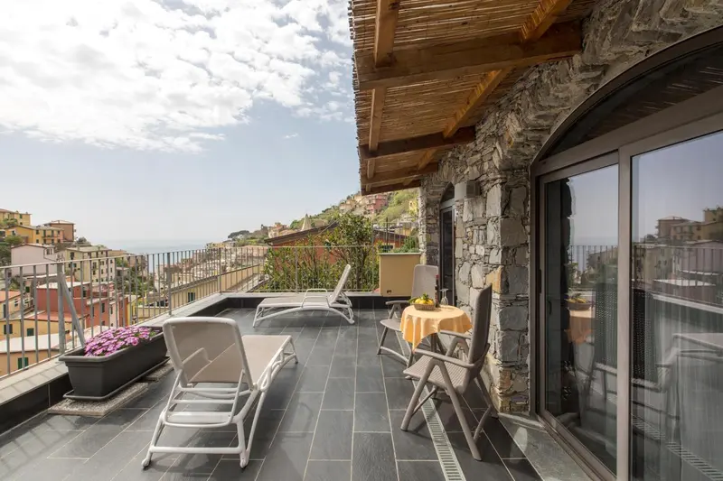 Terrasse avec mobilier d'extérieur et vue sur un paysage montagneux.