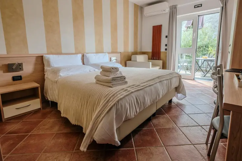 Une chambre lumineuse avec un grand lit et un accès à une terrasse.