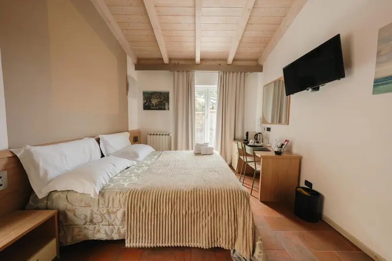 Une chambre lumineuse avec un lit double et un bureau.