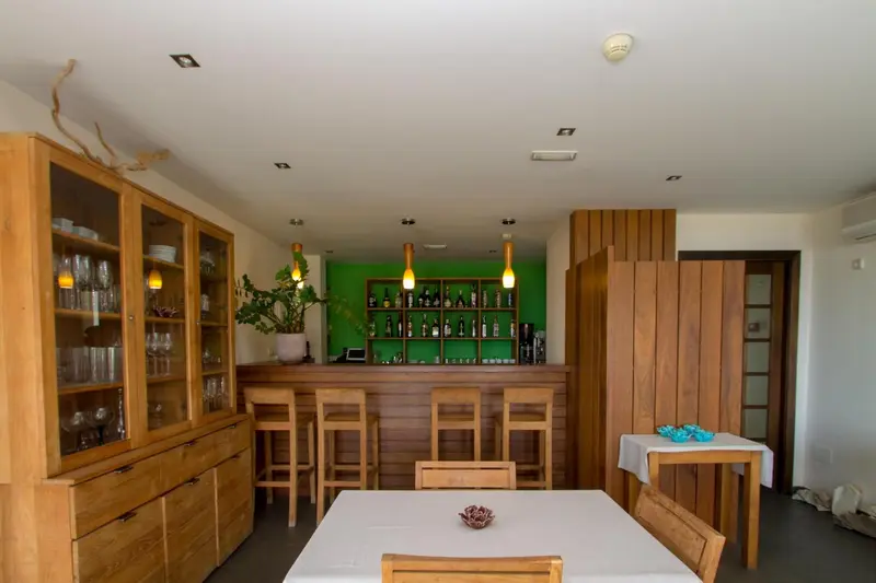 Une salle lumineuse avec un comptoir de bar en bois et des tabourets.