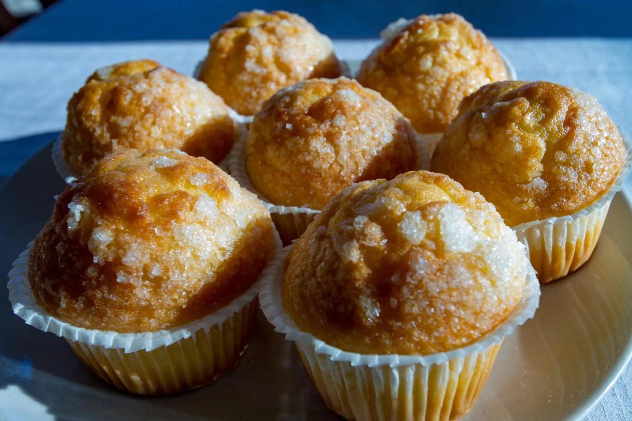 Des muffins dorés sont présentés sur une assiette blanche.