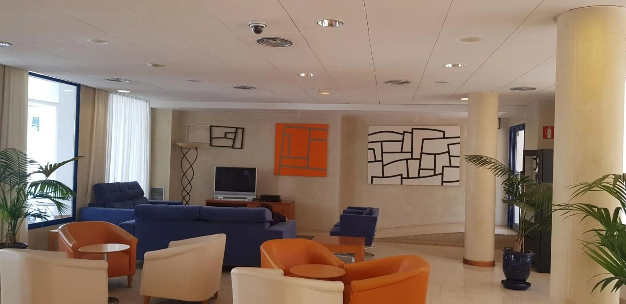 Un espace de détente intérieur avec des canapés et des fauteuils colorés.