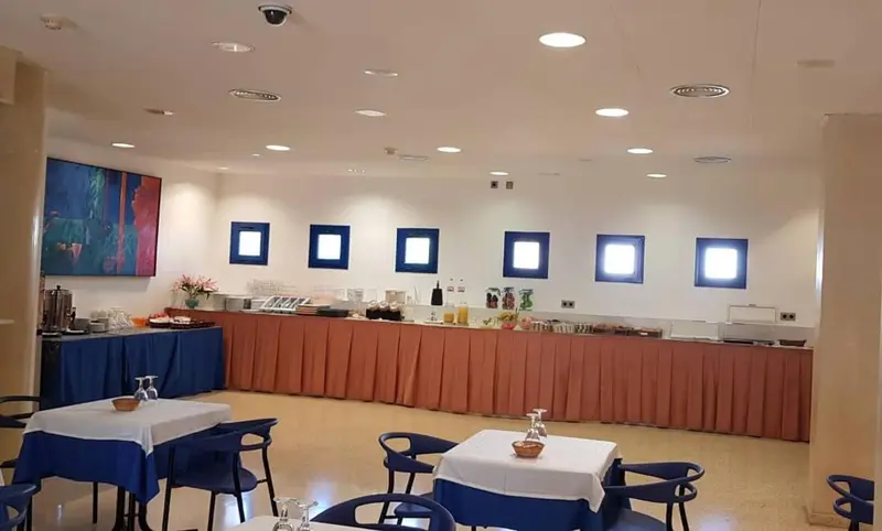 Une salle lumineuse avec un buffet et des tables.