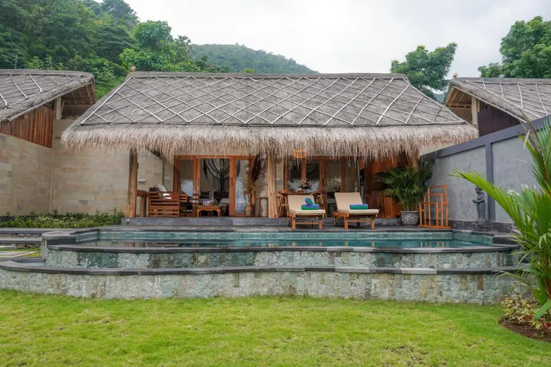 Terrasse privée avec piscine et végétation luxuriante.
