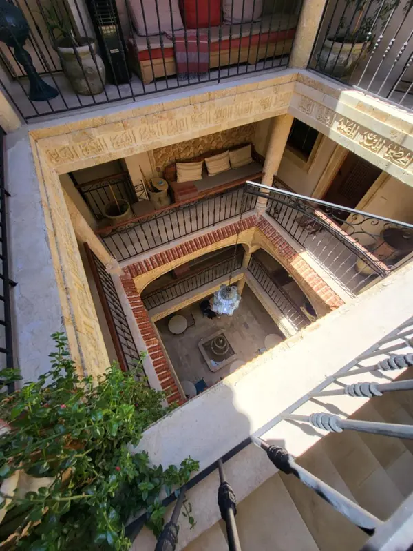Vue d'un patio intérieur avec fontaine et végétation luxuriante.