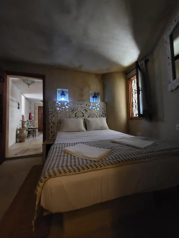 Une chambre à coucher avec un lit décoré et une fenêtre.