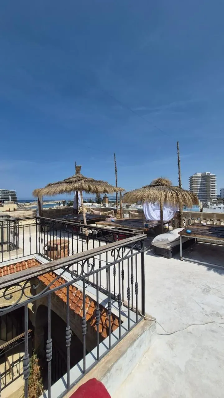 Terrasse ensoleillée avec mobilier de détente et parasols en chaume.