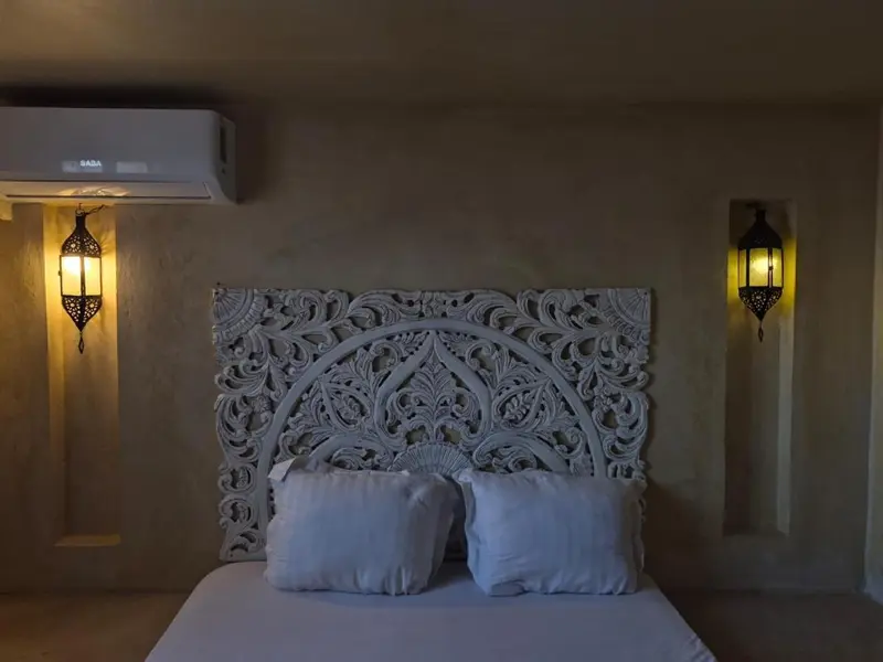 Une chambre à coucher avec un grand lit décoré d'une tête de lit sculptée.