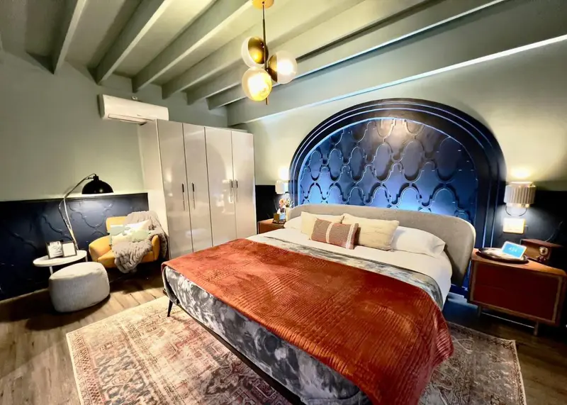 Une chambre à coucher avec un grand lit recouvert d'une courtepointe et un coin salon.