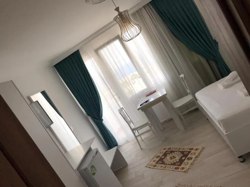 Une chambre lumineuse avec un lit simple et une petite table.