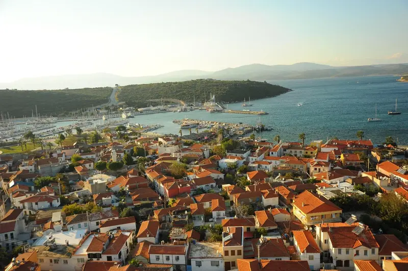 Vue aérienne d'une ville côtière avec des toits rouges et un port de plaisance.