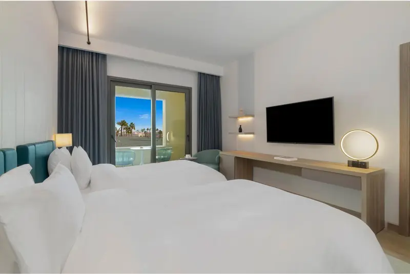 Une chambre lumineuse avec un grand lit et un accès à une terrasse.