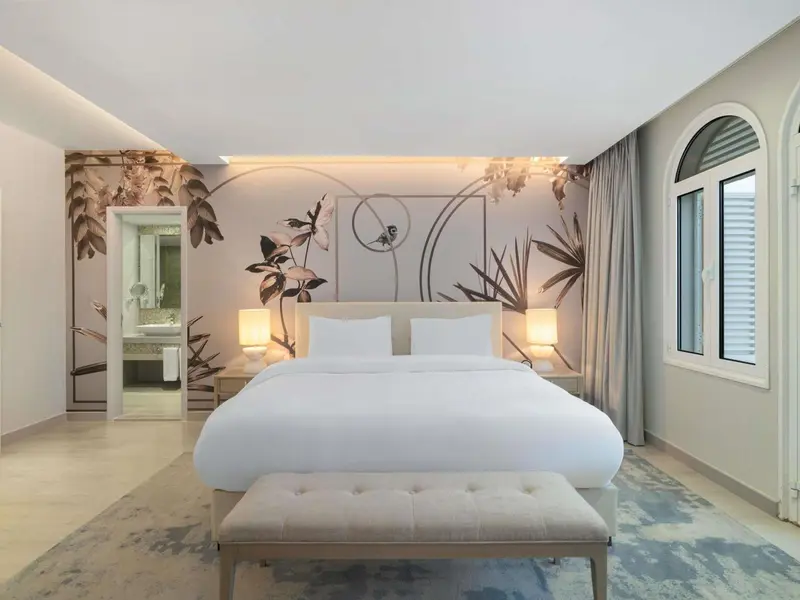 Une chambre lumineuse avec un grand lit et une décoration florale.