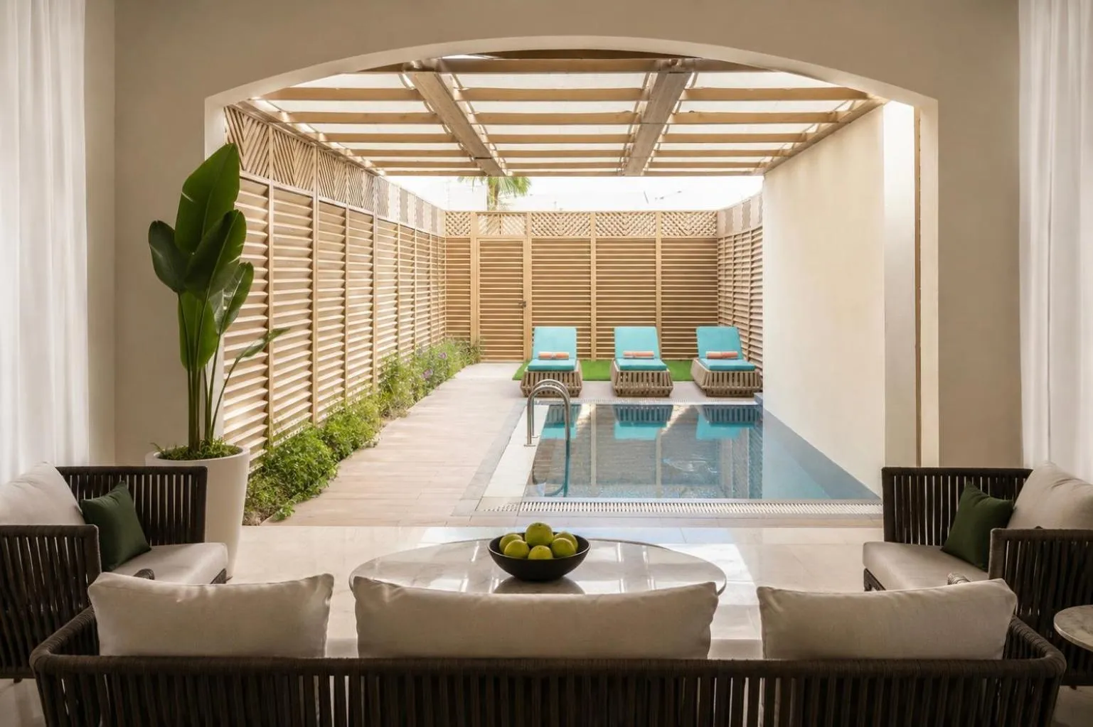 Espace de détente extérieur avec piscine et mobilier de jardin.