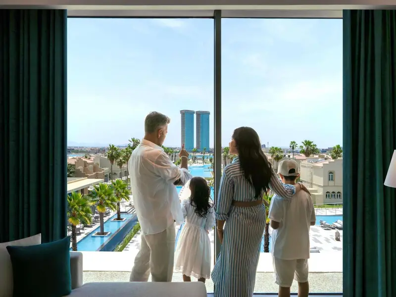 Une famille contemple la vue depuis une chambre d'hôtel.