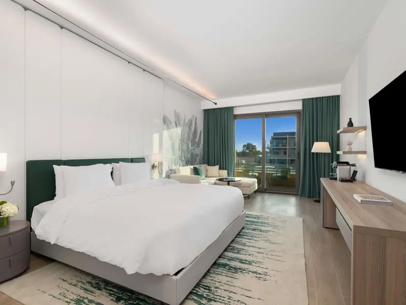Une chambre lumineuse avec un grand lit et un accès à une terrasse.