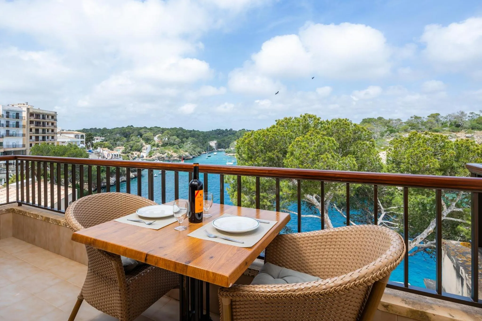 Une table est dressée sur une terrasse avec vue sur la mer et la côte.