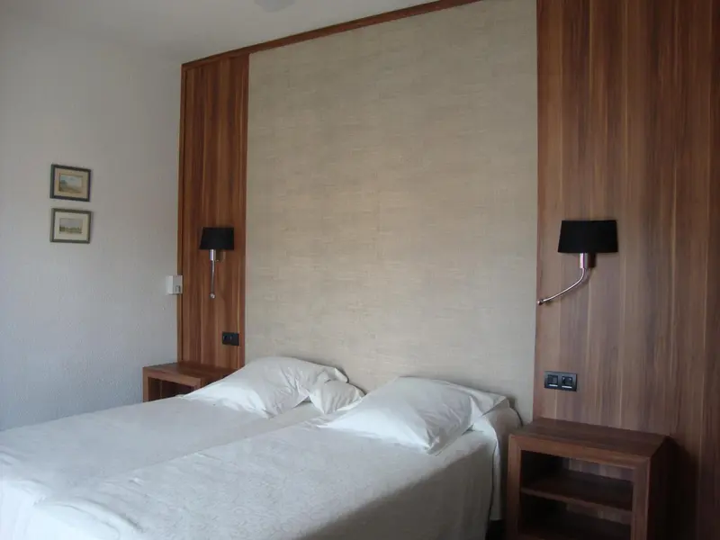 Une chambre avec un grand lit blanc et des tables de chevet en bois.