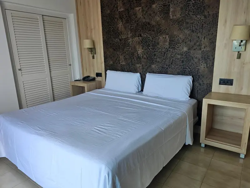 Une chambre lumineuse avec un grand lit recouvert de draps blancs.
