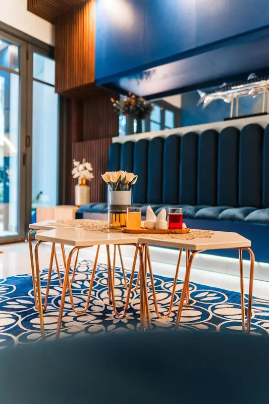 Une table est dressée avec des couverts et des boissons dans un intérieur moderne.