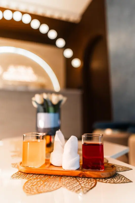 Deux verres de boissons colorées et des serviettes pliées sur une table.