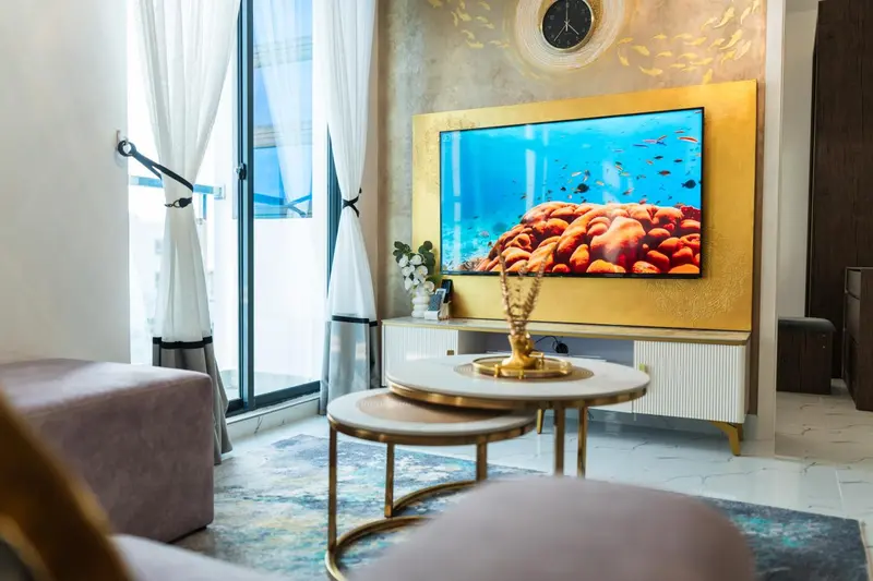 Un salon moderne avec un grand téléviseur mural diffusant une scène sous-marine.