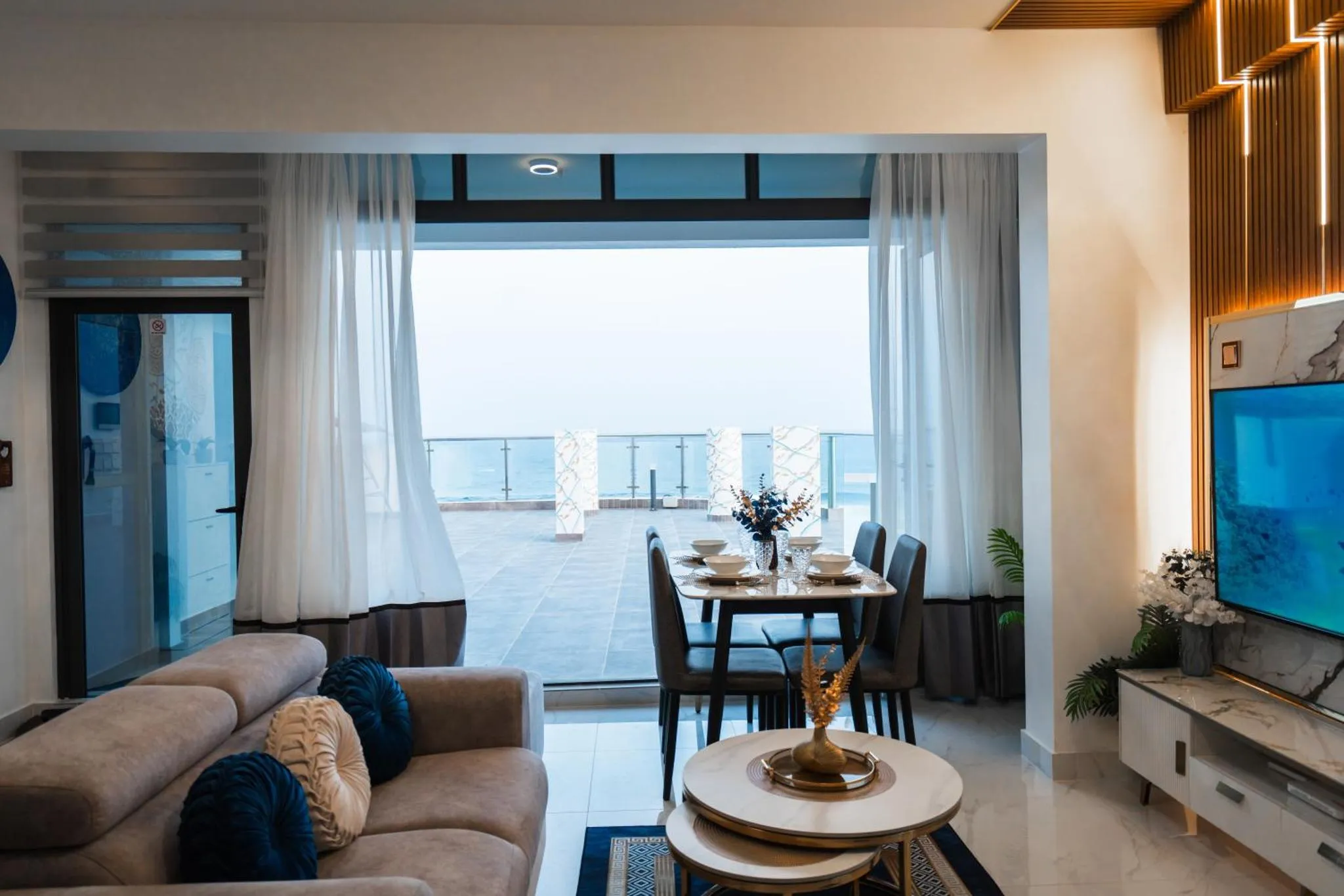 Un salon lumineux s'ouvre sur une terrasse avec vue sur la mer.