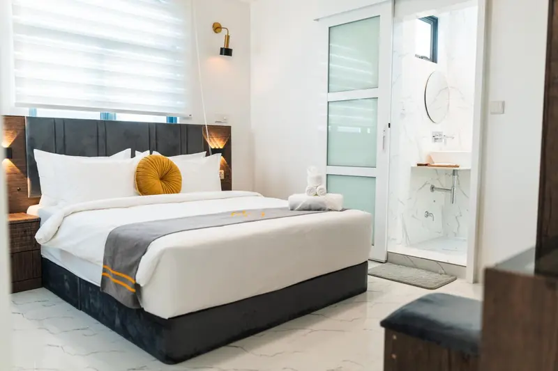 Une chambre lumineuse avec un grand lit et une salle de bain attenante.